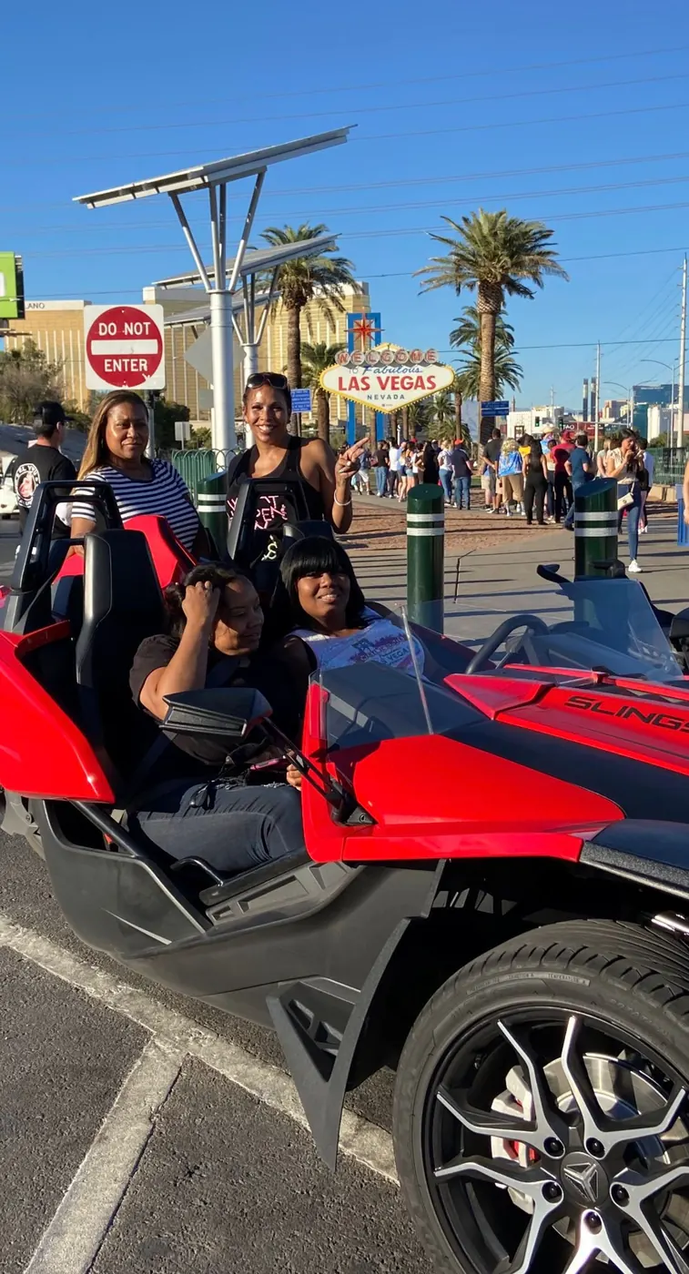 Red Polaris Slingshot near the Welcome to Las Vegas sign